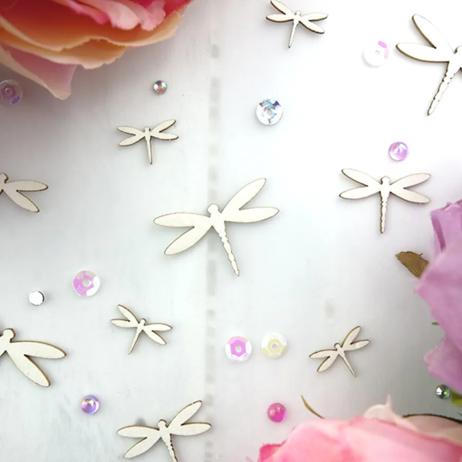 Laser-cut chipboard dragonflies.
